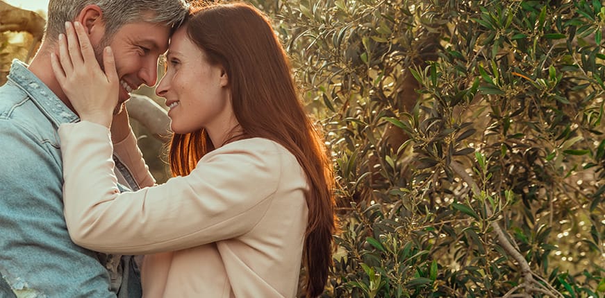 Woman Lovingly Holding Mans Face and Smiling